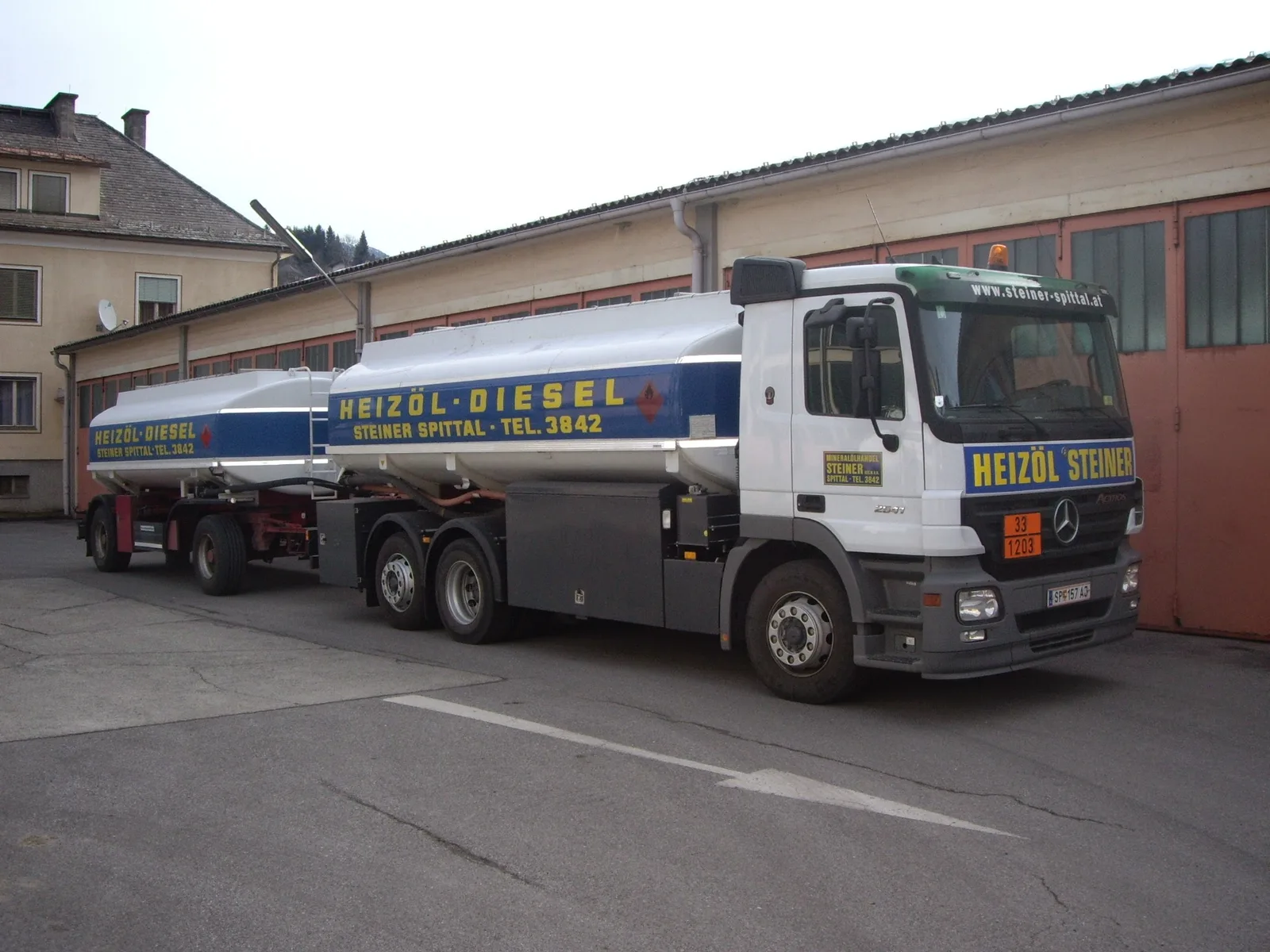 Tankzug mit Anhänger und der Aufschrift Heizöl Steiner vor der Halle
