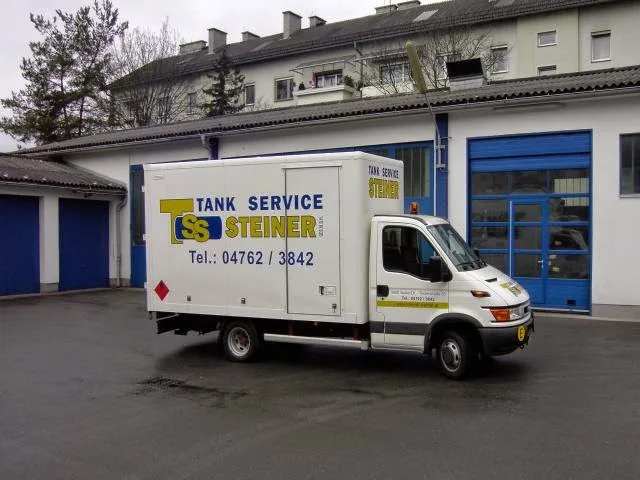 Weißer Kastenwagen mit der Aufschrift Tank Service Steiner vor der Halle