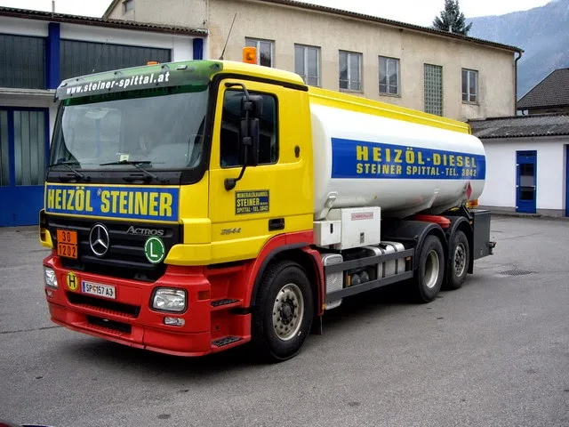 Gelb-roter Tankwagen mit der Aufschrift Heizöl Steiner im Hof